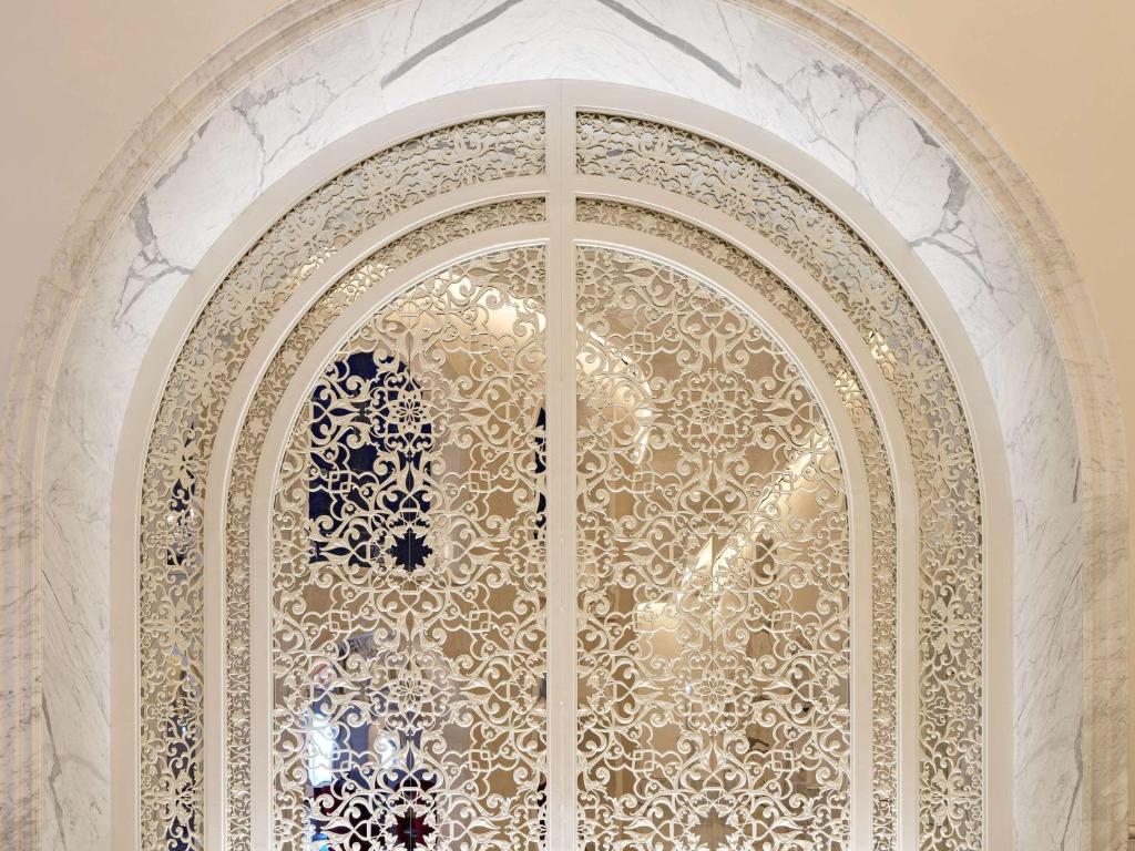 una porta di vetro decorata in un edificio di Raffles Doha a Doha