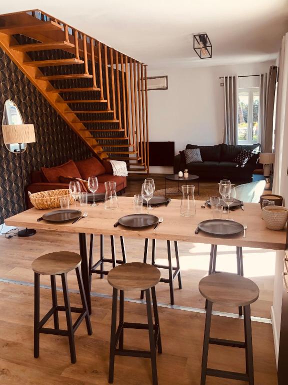 - un salon avec une table et des verres à vin dans l'établissement Villa Les mûriers, à Saint-Hilaire-du-Rosier