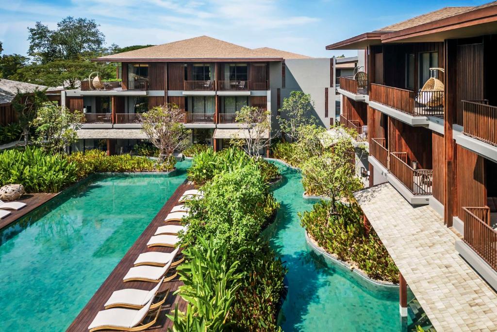 eine Aussicht über einen Pool mit Liegen in der Unterkunft Andaz Pattaya Jomtien Beach, a Concept by Hyatt in Na Jomtien