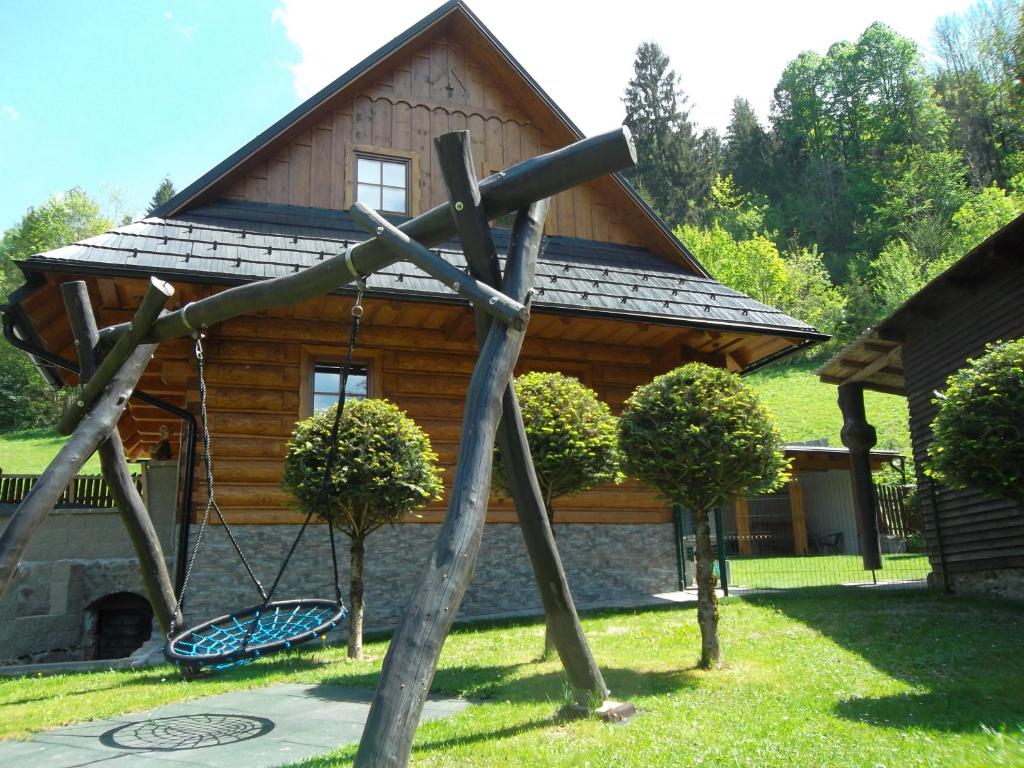 a log cabin with a swing in front of it at Chata Sipkova II in Terchová