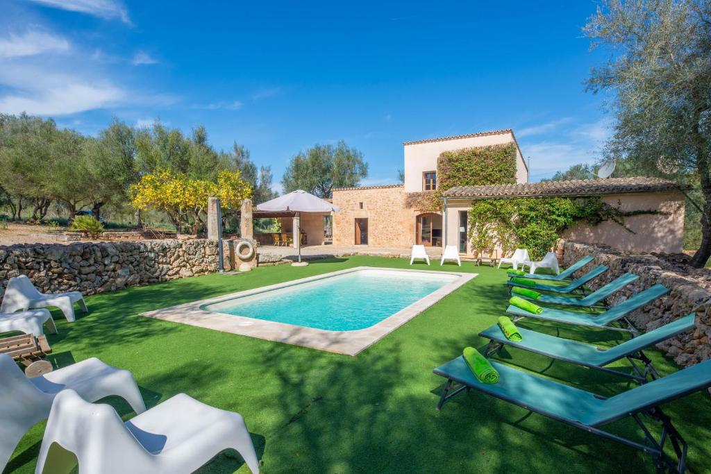 uma imagem de uma villa com uma piscina e espreguiçadeiras em Can Pere Rapinya em Algaida