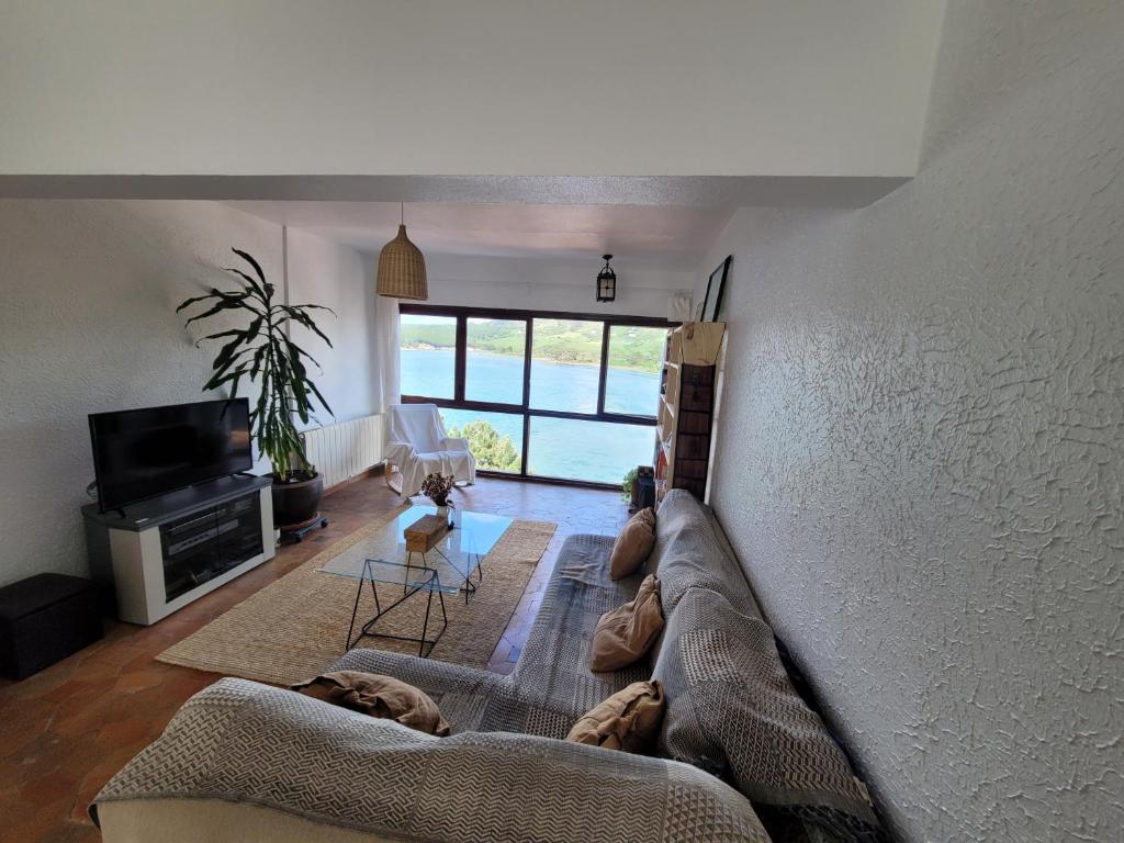 ein Wohnzimmer mit einem Sofa und einem TV in der Unterkunft Duplex con Vistas a la Ria in Miengo