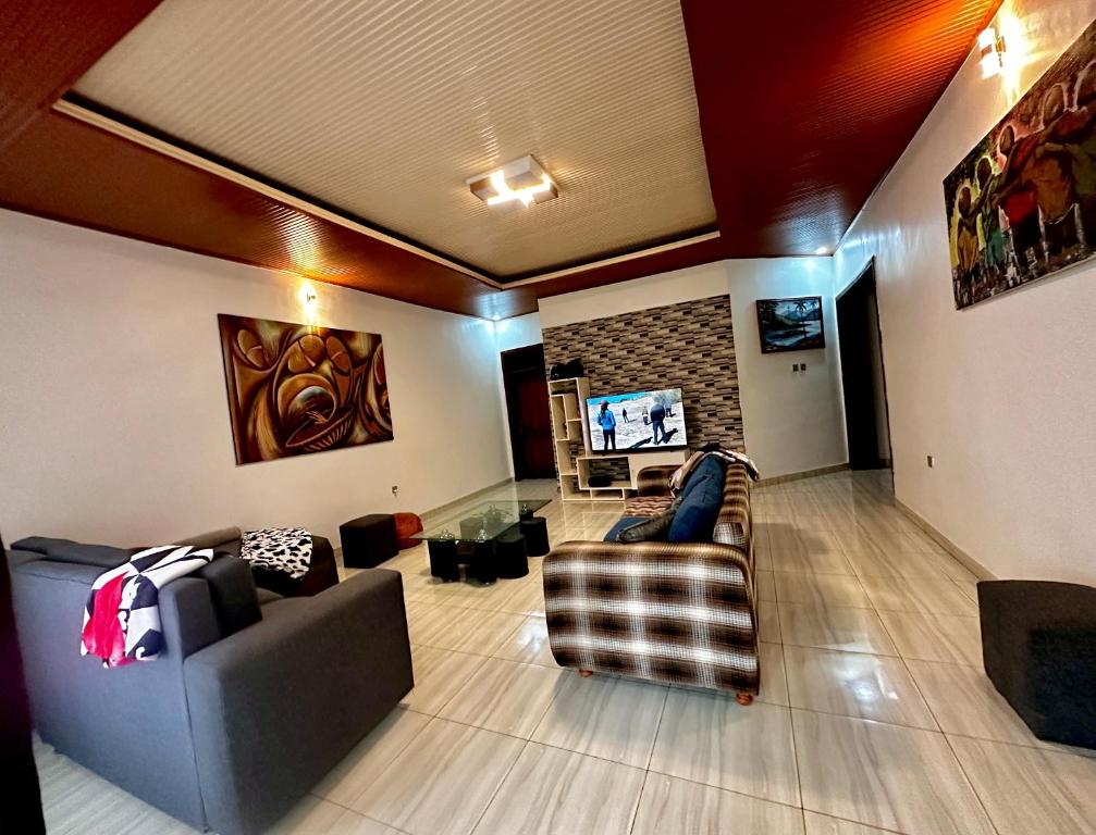 uma sala de estar com dois sofás e uma televisão em Inshuti Home Stay 