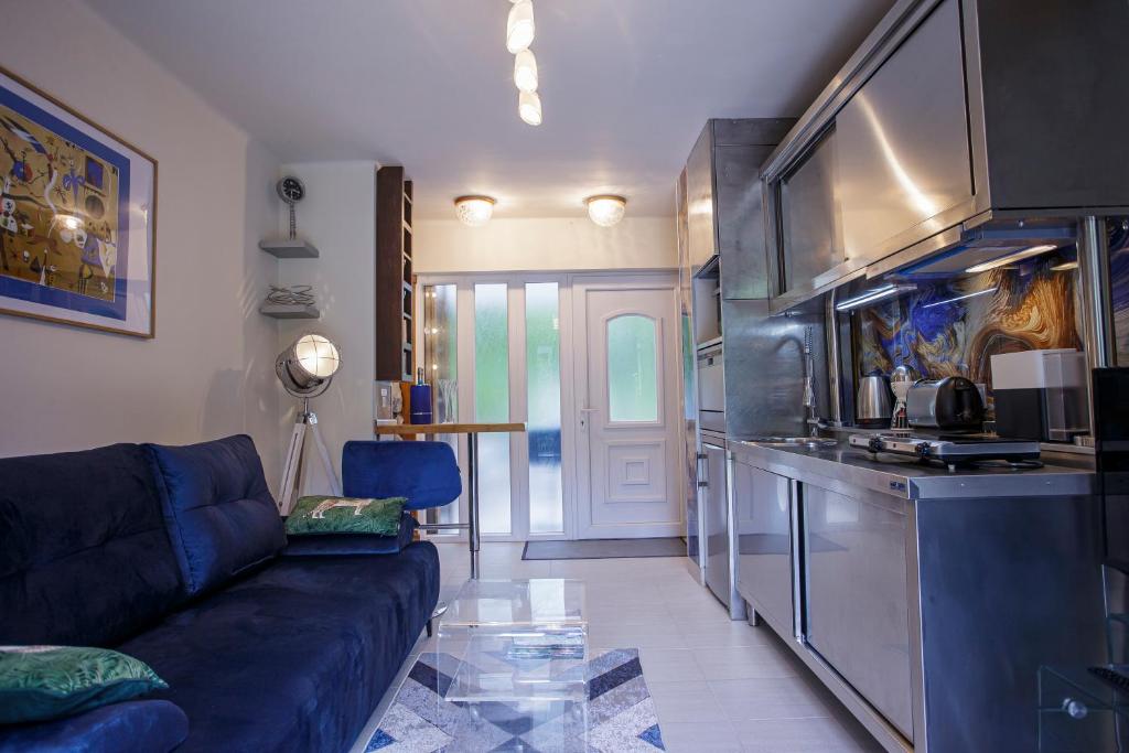 Il comprend un salon avec un canapé bleu et une cuisine. dans l'établissement Riverside Apartman Szentendre, à Szentendre