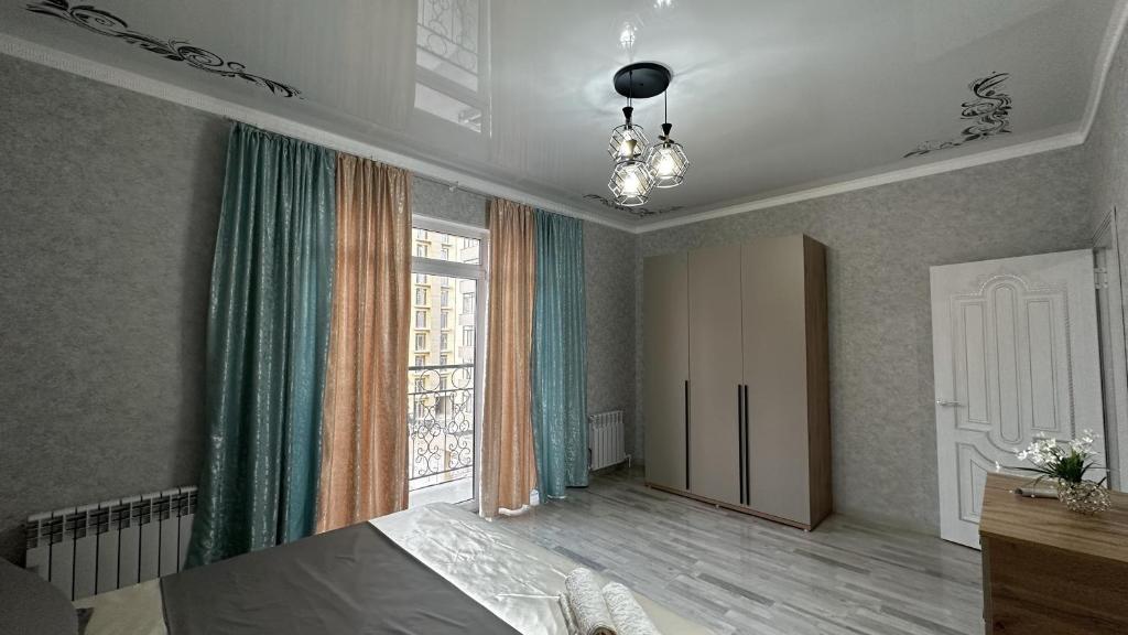 a bedroom with a bed and a large window at Квартира в Туркестане in Tridtsatʼ Let Kazakhstana