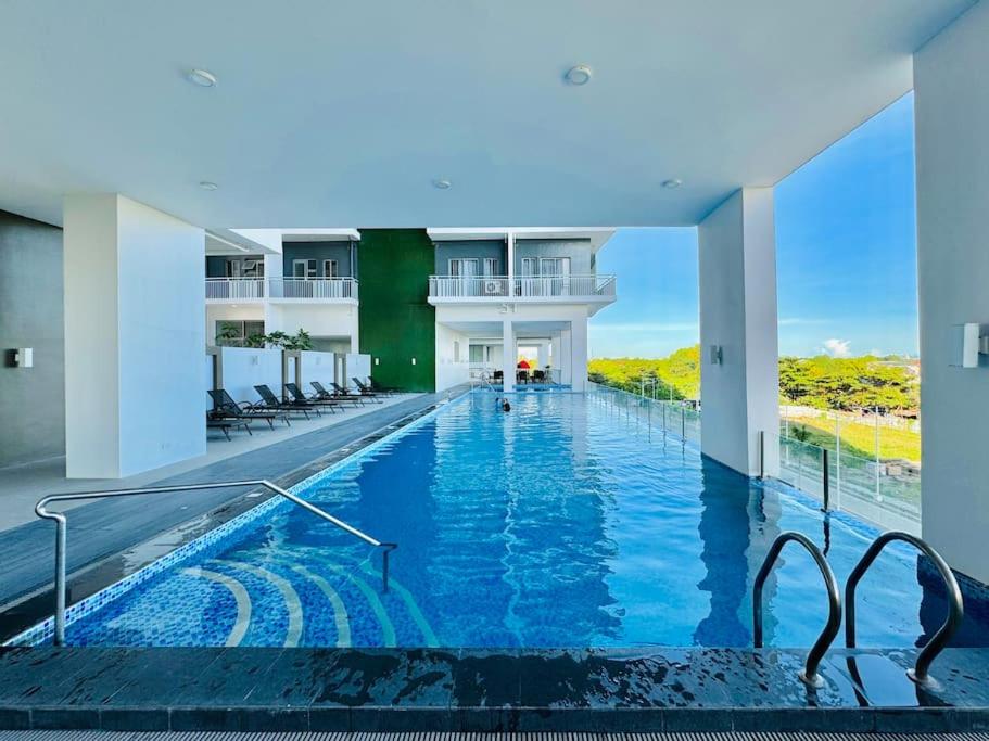 a large swimming pool with chairs in a building at WV 9 Best Value Barkada Room in Iloilo City