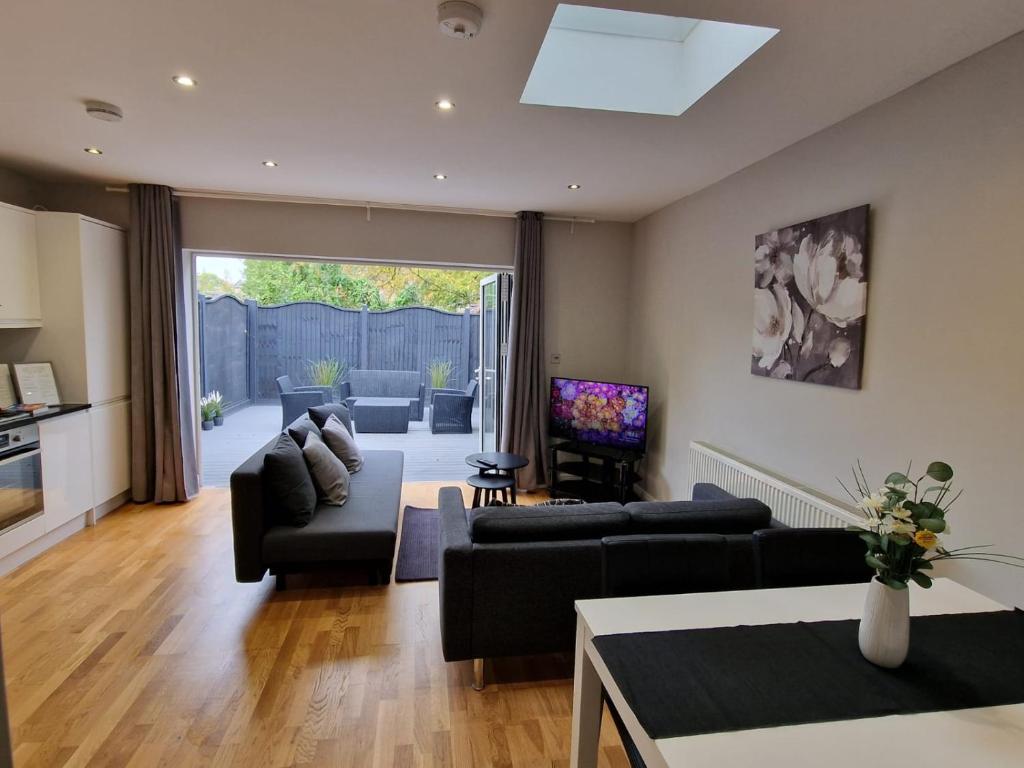 a living room with a couch and a table at New! Lovely 2 Bed Serviced Apartment with free parking in London