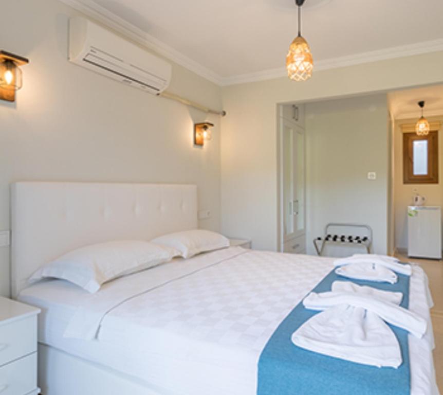 Yakaköy的住宿－KIYI SUITES Otel，一间卧室配有一张大白色床和蓝色毯子