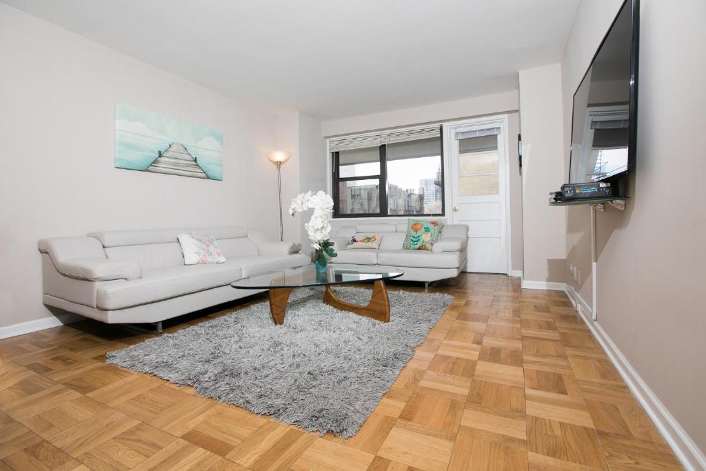 a living room with a white couch and a table at Spectacular 2 Beds/2 Baths Apartment in New York