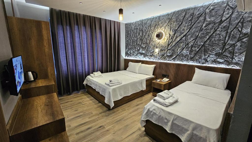 Una habitación de hotel con dos camas y un televisor. en Rever Hotel, en Sanlıurfa
