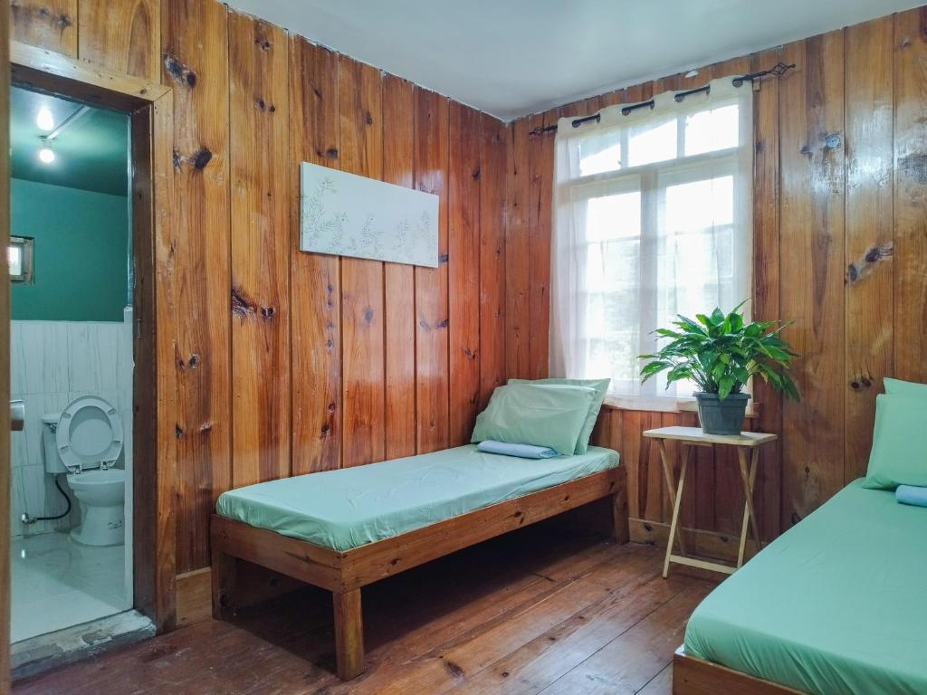een kamer met een bank, een toilet en een raam bij Rm 207 Mhapiya-aw Pensione Inn in Sagada