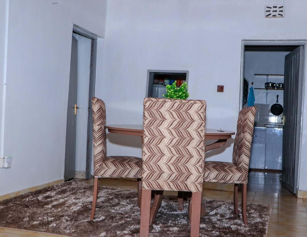 ein Esszimmer mit einem Tisch und 2 Stühlen in der Unterkunft Perfection in Meru