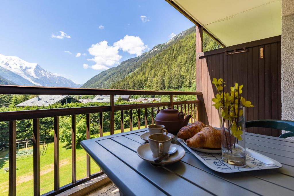 einen blauen Tisch mit einem Teller Essen auf dem Balkon in der Unterkunft Résidence Grands Montets 502 ski in-ski out - Happy Rentals in Chamonix-Mont-Blanc