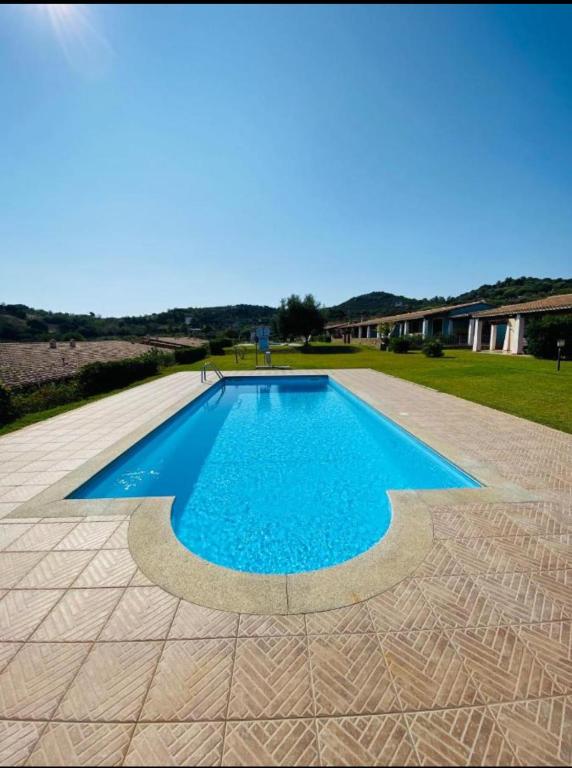a swimming pool with blue water in a yard at Villa Beafe' Ogliastra con piscina in Tertenìa