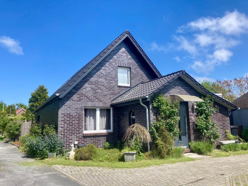 een stenen huis met een gambrel dak bij Haus NEDAL by fewo-plan NEUG100 an der Nordsee bei Carolinensiel-Harlesiel in Wangerland