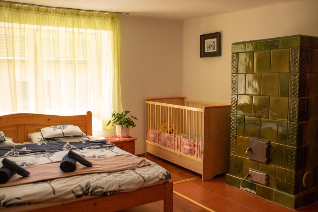 a bedroom with a bed and a crib at Európa Szíve vendégház in Tállya