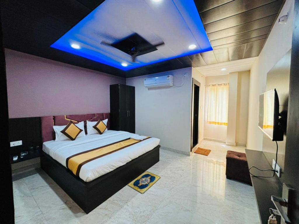 Goroomgo Hotel Imperial Varanasi - Wonderfull Stay with Family في فاراناسي: غرفة نوم مع سرير بسقف ازرق