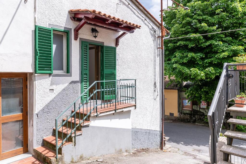 um edifício com persianas verdes e uma escadaria em Casa Prataccio em Prataccio