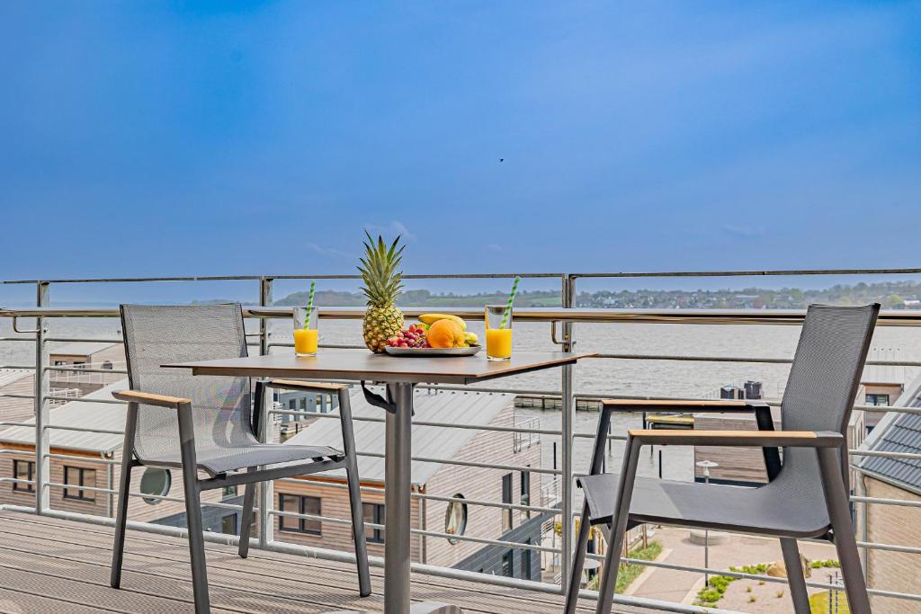 - une table avec un bol de fruits sur le balcon dans l'établissement Ferienwohnung Wiking-Koje 10 Schleswig, à Schleswig