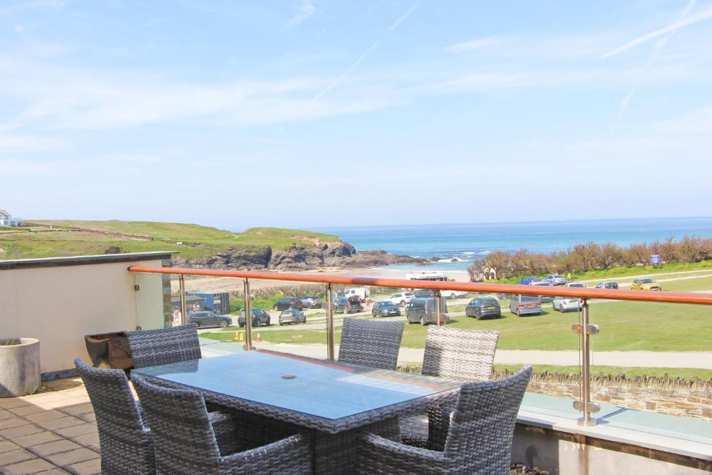 ein Balkon mit Tisch und Stühlen und dem Meer in der Unterkunft Contemporary beachside apartment in Saint Merryn
