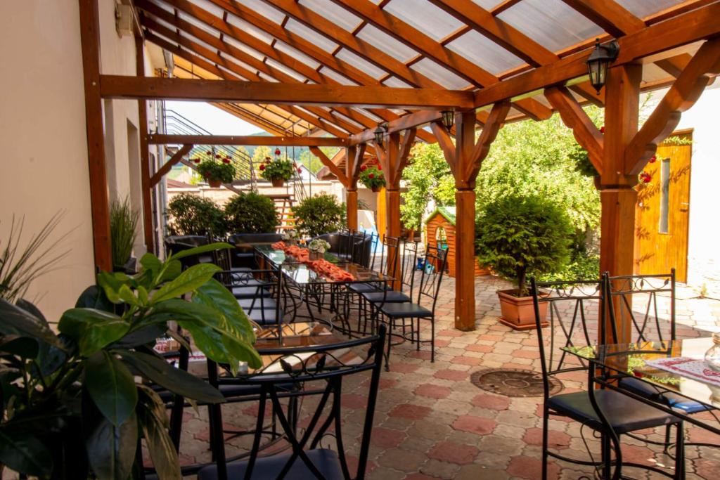a patio with tables and chairs under a wooden pergola at Penzión CONTESA in Rožňava