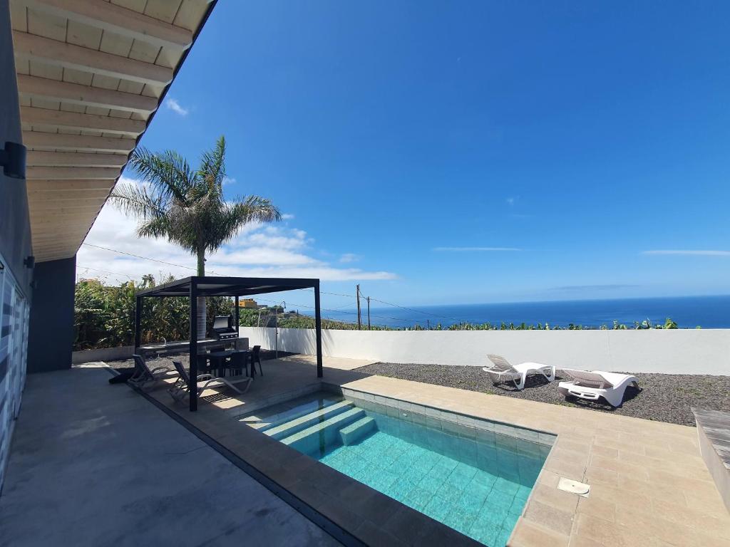 une maison avec une piscine et une vue sur l'océan dans l'établissement Villa Puesta de Luna, à Tazacorte