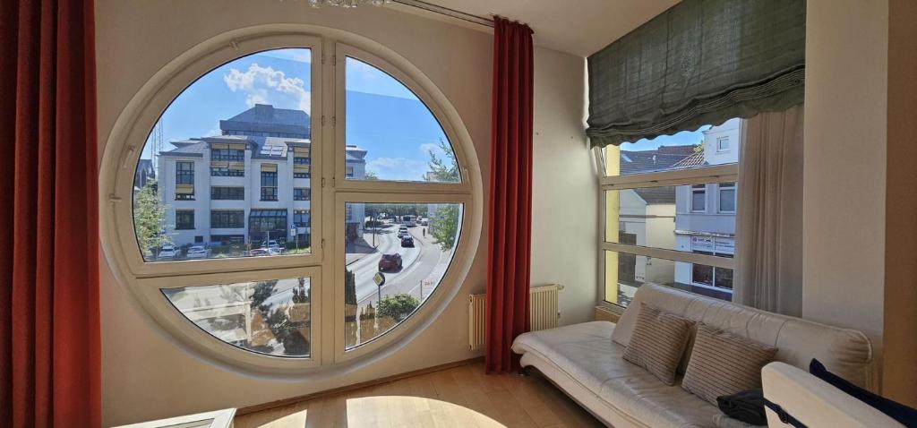 una ventana abovedada en una sala de estar con vistas a la ciudad en Helle Wohnung mit sonnigem Ausblick, in zentraler Lage 135 qm, 4 Zimmer Wohnung, en Oldenburg