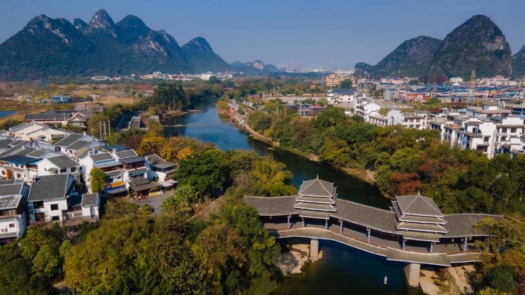 Luftblick auf eine Stadt mit Fluss und Brücke in der Unterkunft The Beyond Villa Guilin in Guilin