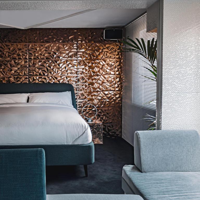 a bedroom with a bed with a wooden accent wall at Luxury Studio - Manchester City Centre in Manchester