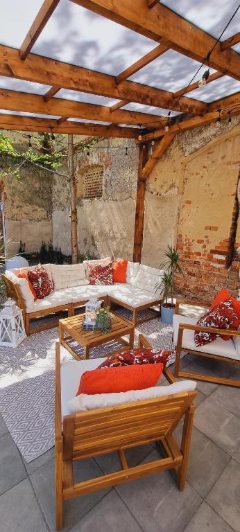 a patio with couches and tables and a wooden roof at Glamping Tajemniczy Ogród in Strzelin