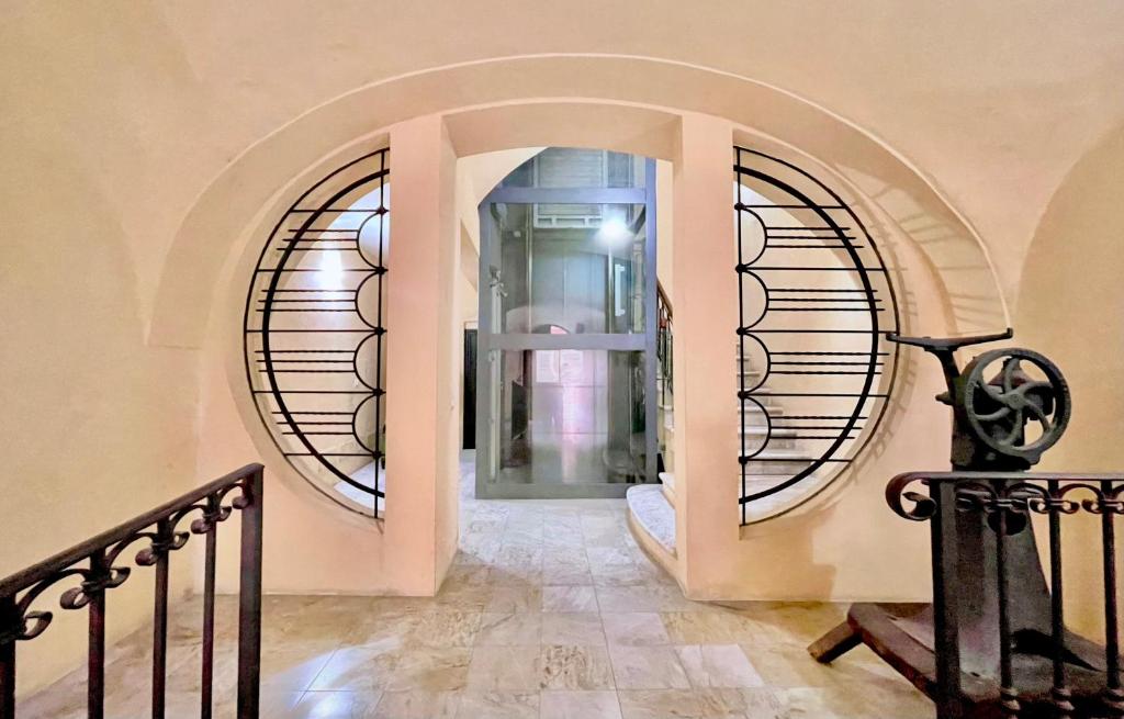 a hallway with two circular windows in a building at Sardinian Gallery Corso in Bosa