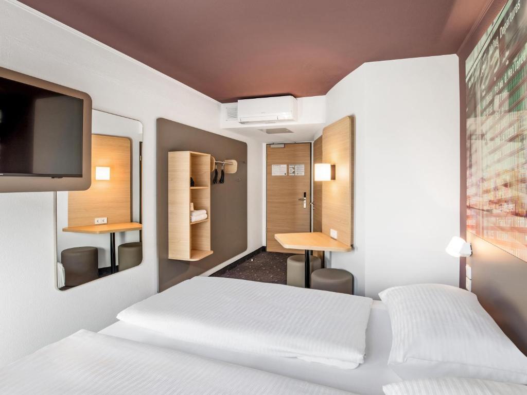 a hotel room with two beds and a tv at B&B Hotel Hamburg-Airport in Hamburg