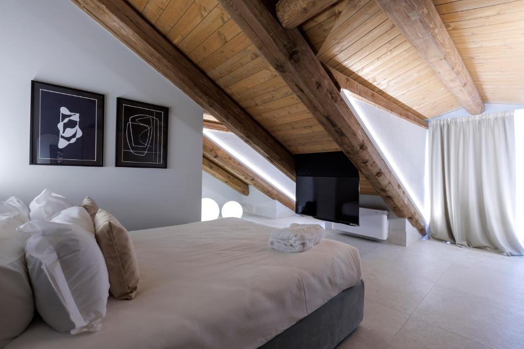 una camera con un grande letto e una TV di Palazzo Bellezia Luxury Suites a Torino