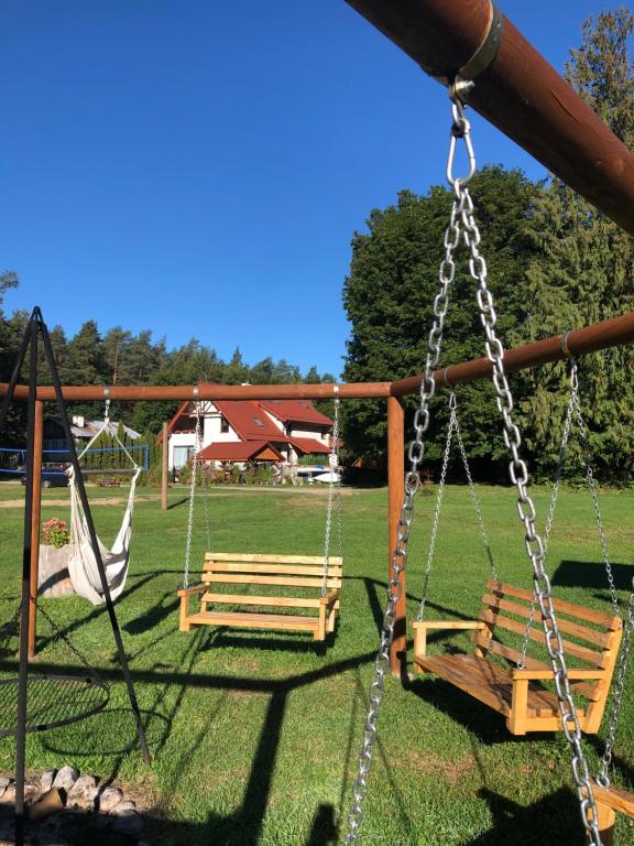 two swings in a park with a yard at Pokoje Cztery Pory Roku in Mikołajki