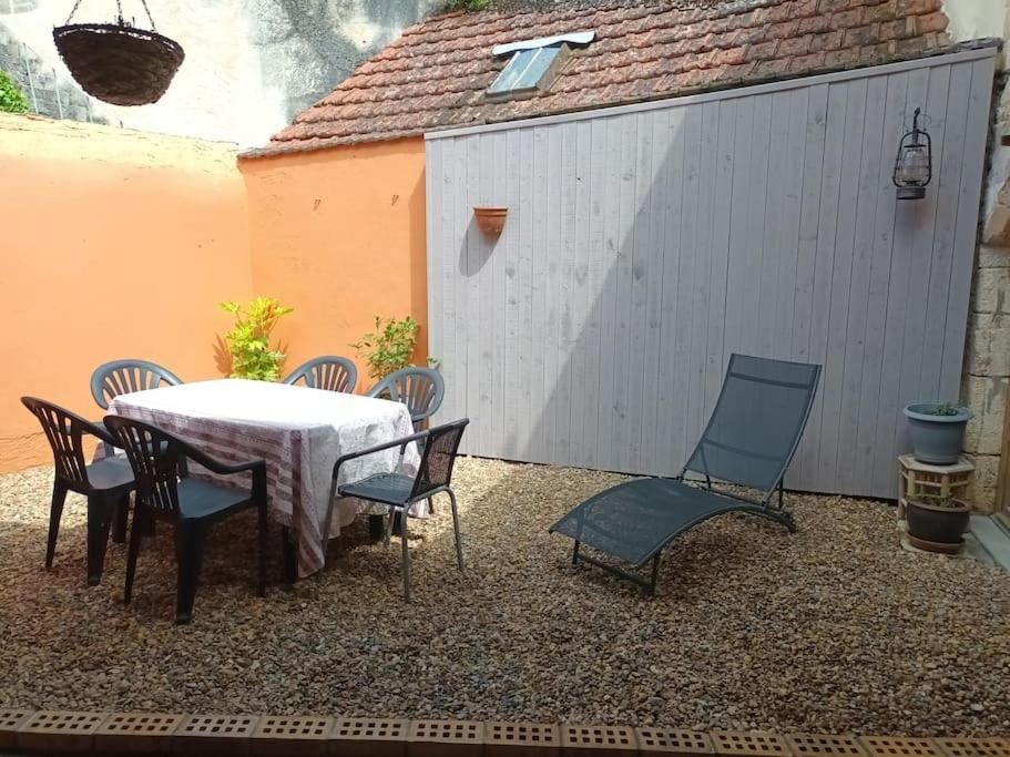 a patio with a table and chairs and a fence at Maison avec cour, Centre historique Be Happy in La Charité-sur-Loire
