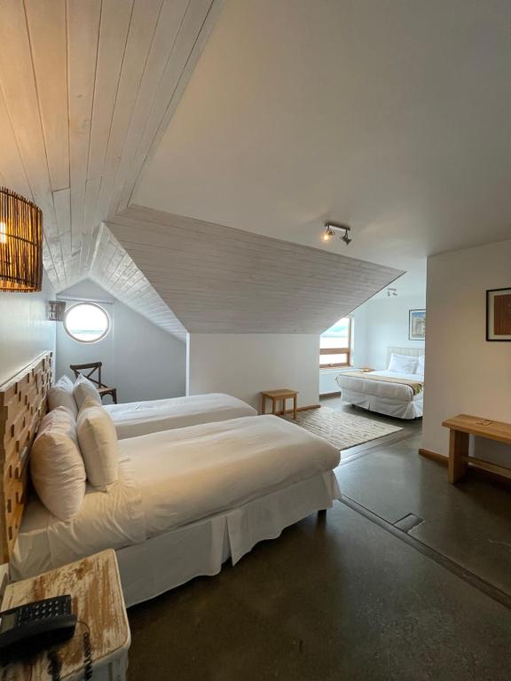 1 dormitorio con 1 cama grande en una habitación en Weskar Lodge Hotel, en Puerto Natales