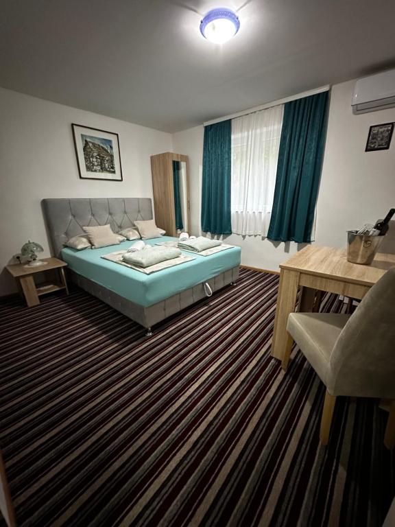 um quarto com uma cama, uma mesa e uma cadeira em Guest House Nana em Mostar