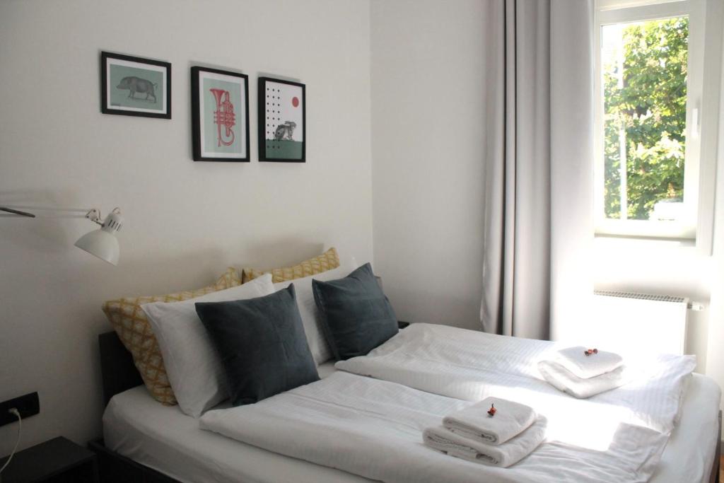 una camera da letto con un letto bianco e asciugamani di Zest and Nest Boutique Apartments a Zagabria
