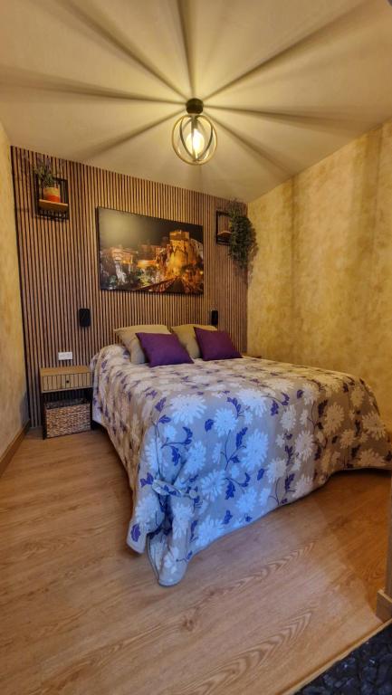 a bedroom with a large bed with purple pillows at Apartamento EL TORMO DE CASA BOTES in Cuenca