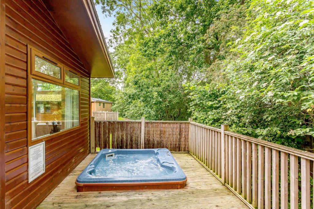 una bañera de hidromasaje en la cubierta de una casa en Norton Lodge 18, en Kingham