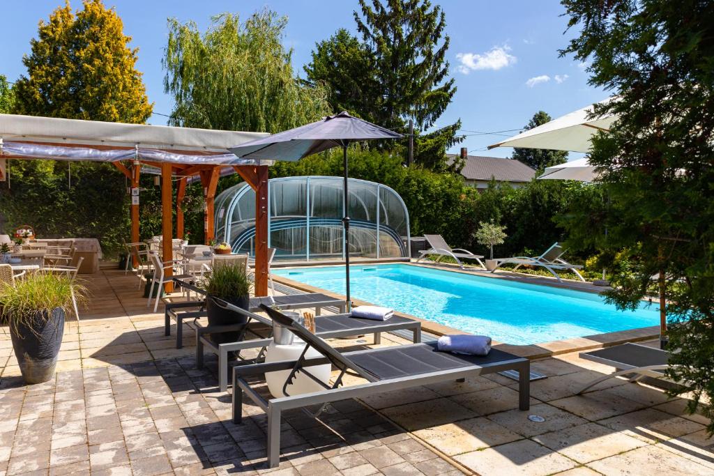 una piscina con tumbonas y sombrilla en Balaton Fantasy Villa, en Balatonfüred