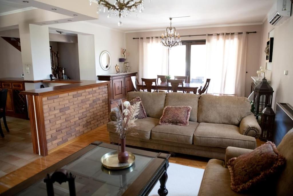 a living room with a couch and a table at Βίλα Μαρία Νεφέλη για μαγικές διακοπές στο νησί μας in Panormos Kalymnos
