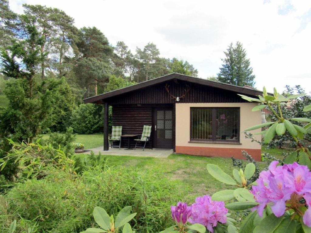 a cottage with a table and chairs in a yard at Ferienhaus in Neustadt-Glewe in Neustadt-Glewe