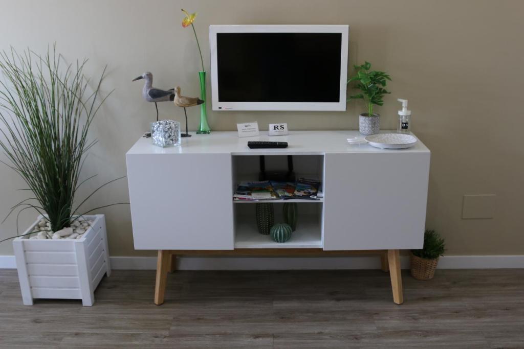 ein weißer Schreibtisch mit einem Monitor darüber in der Unterkunft RS Apartamento in Quarteira