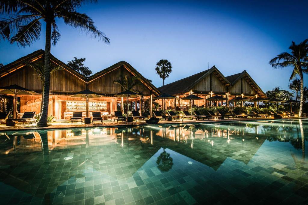 a resort with a swimming pool at night at Zannier Hotels Phum Baitang in Siem Reap