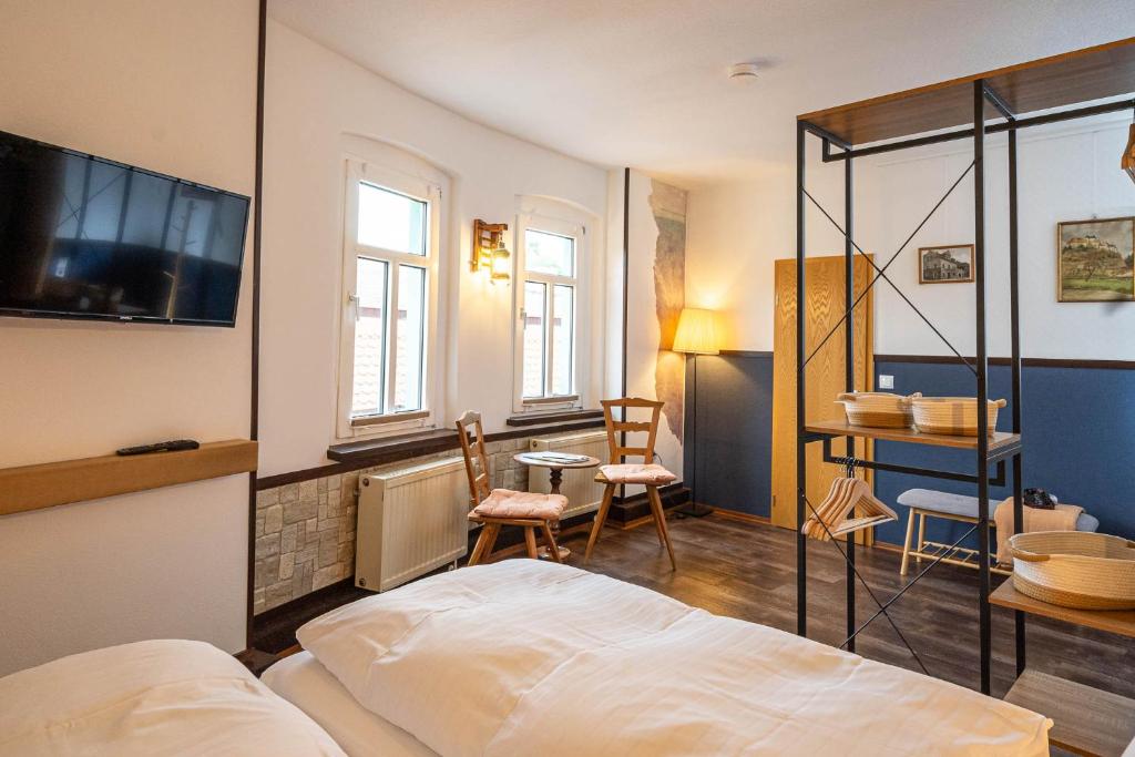 um quarto com uma cama, uma mesa e cadeiras em Pension Zur Neuenburg em Freyburg