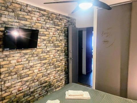 a bedroom with a tv on a brick wall at Le Passe-Port pour Marseille in Marseille