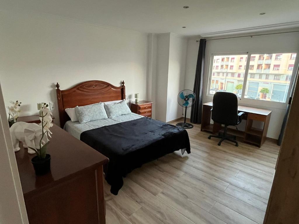 a bedroom with a bed and a desk and a window at Europa Moderna Apartamento in Gandía