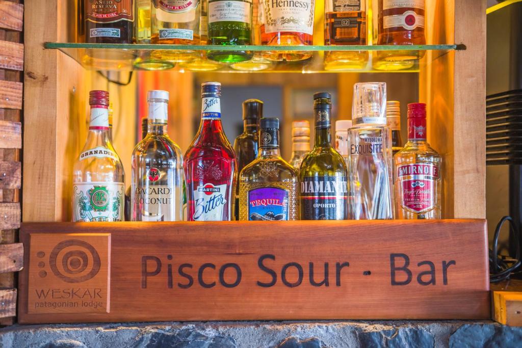 a bar with a bunch of bottles of alcohol at Weskar Lodge Hotel in Puerto Natales