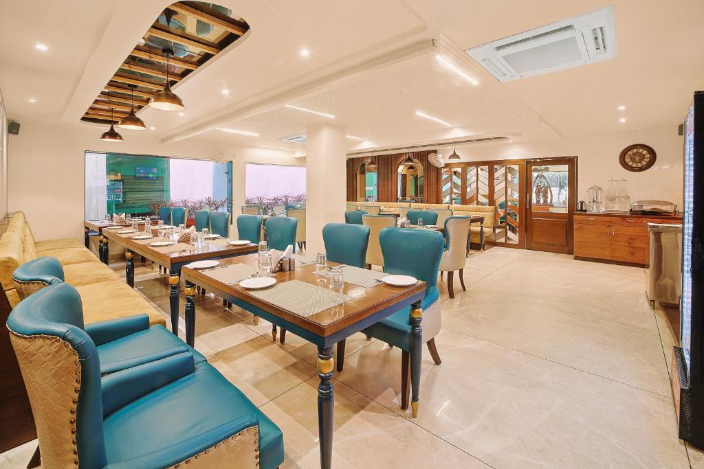 restauracja z długimi stołami i niebieskimi krzesłami w obiekcie Green Hotel - Behind Parmarth Niketan w mieście Rishikesh